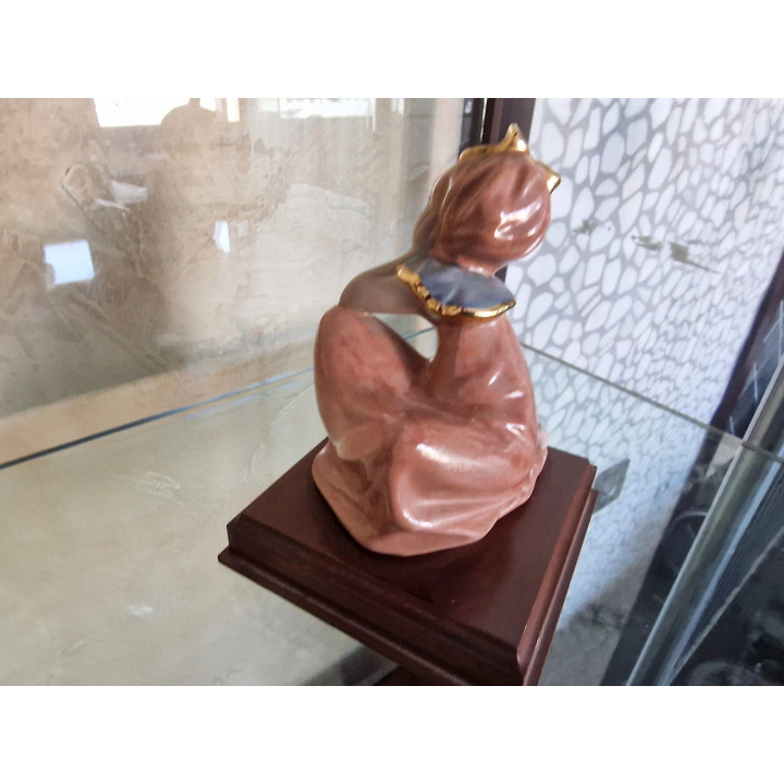 Escultura de Porcelana Joven con Arco Dorado y Base de Madera