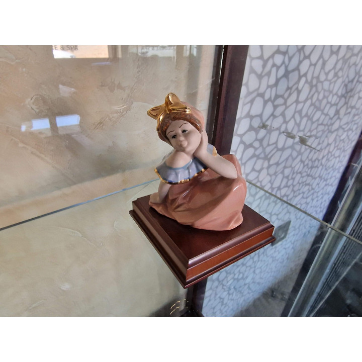 Escultura de Porcelana Joven con Arco Dorado y Base de Madera